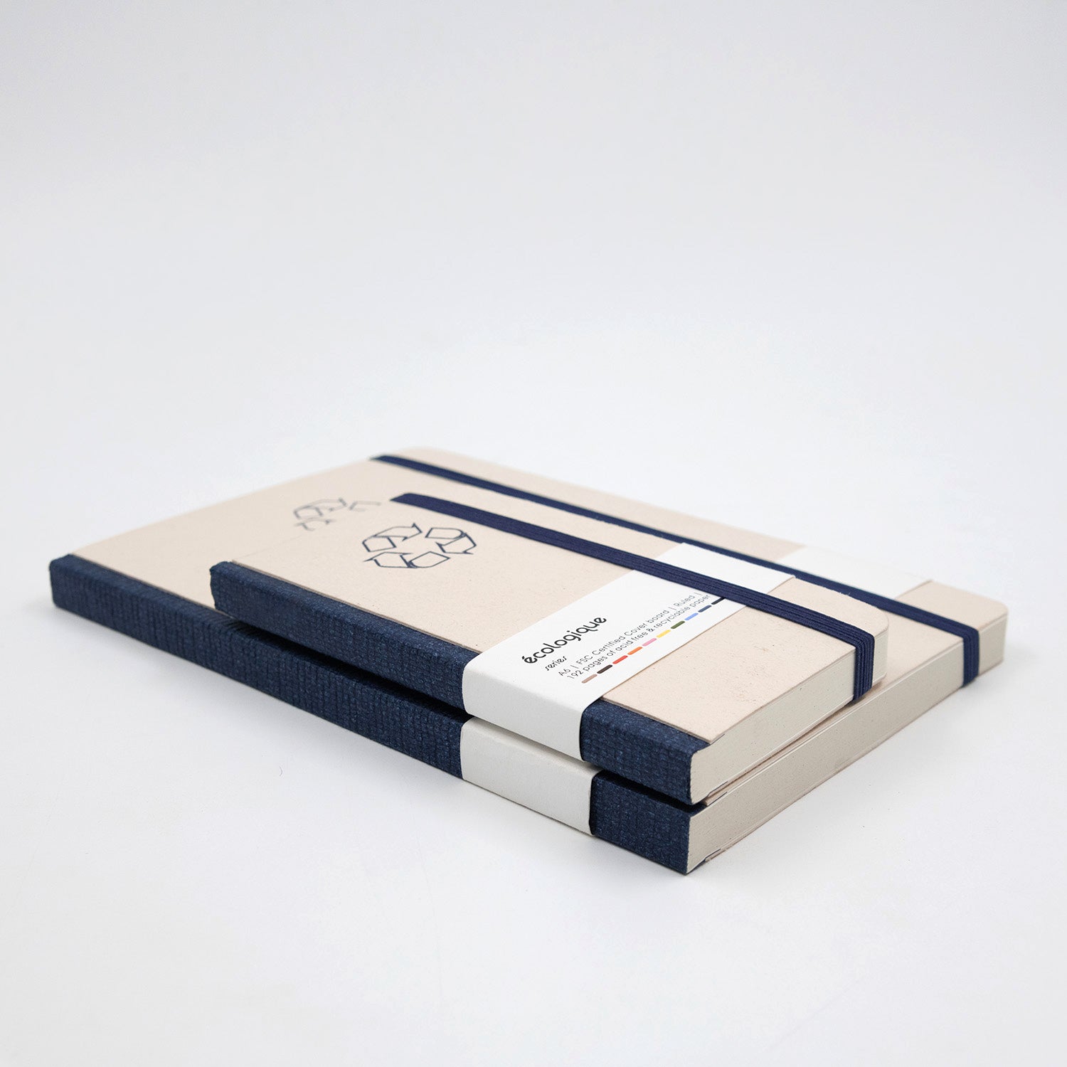 Two notebooks with navy blue straps on a white background