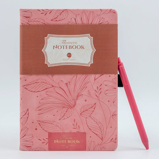 A5 size hard bound notebook with a floral design on the cover, accompanied by a black pen. The notebook is pink with a brown debossed text and flower accents.