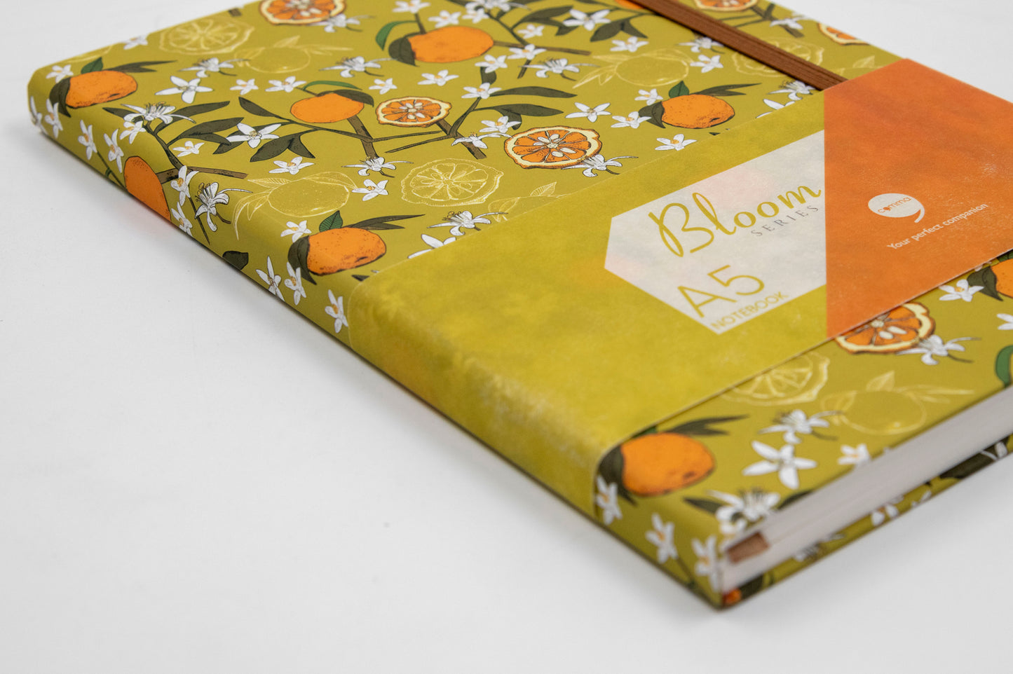 A5 size hard bound notebook with a lime green cover featuring a floral design and the brand 'Comma' visible.