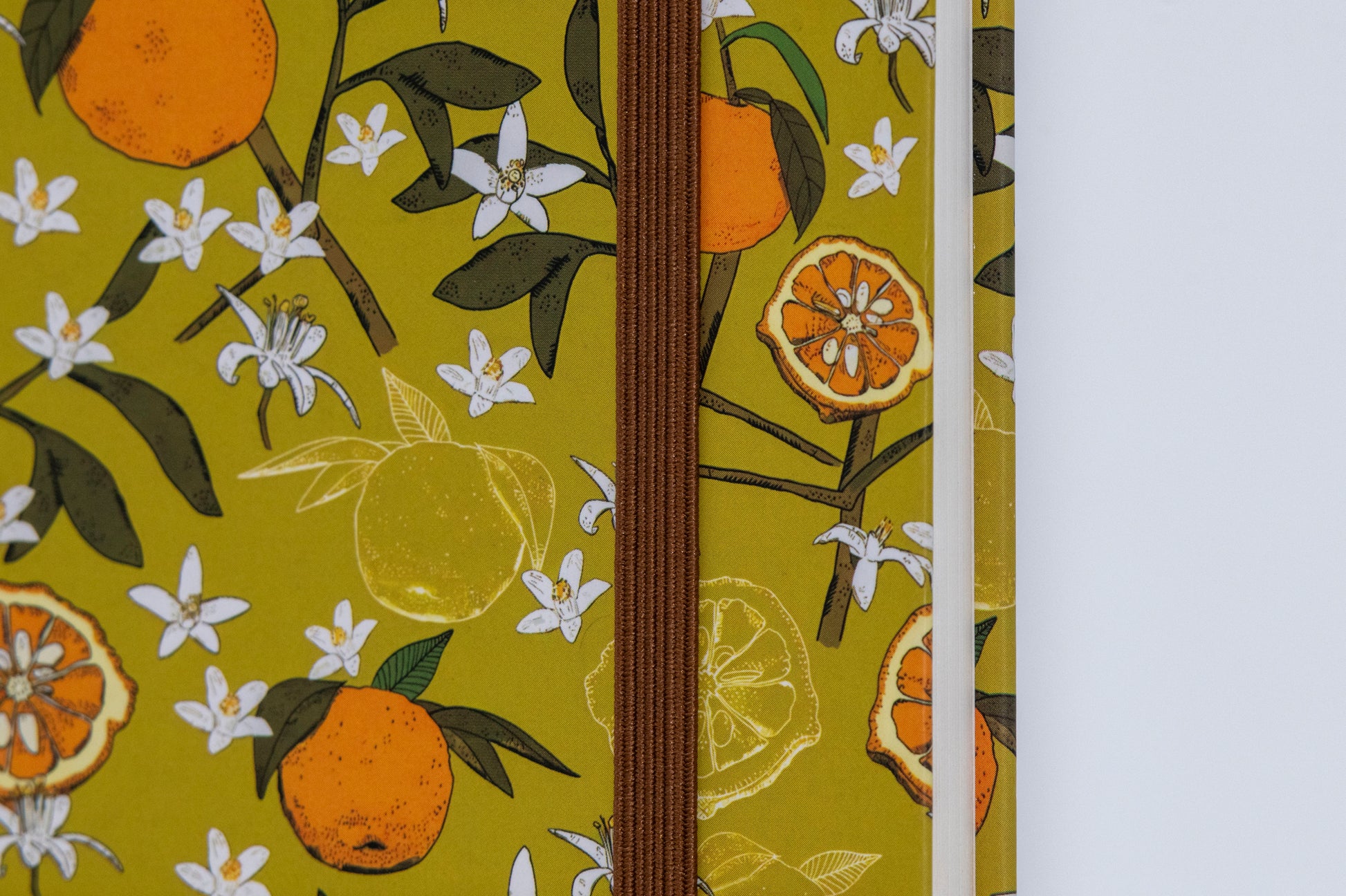 A5 size hard bound notebook with a lime green cover featuring a floral design and the brand 'Comma' visible.