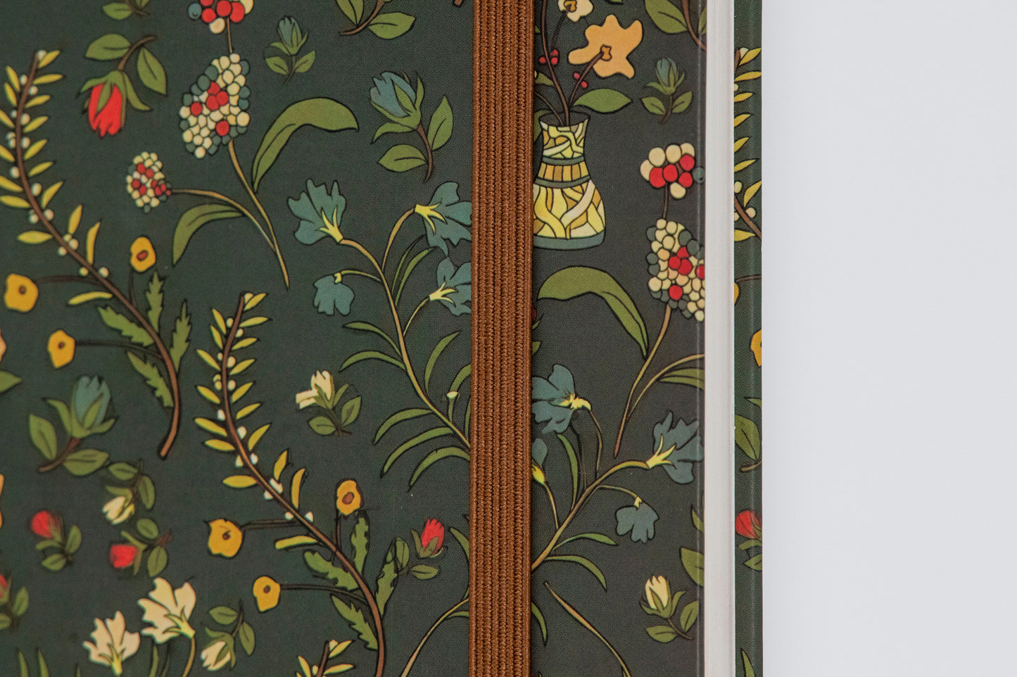A5 size hard bound notebook with a dark green floral-themed design and a brown hard cover.